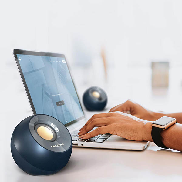 قرارگیری اسپیکر دسکتاپ کریتیو مدل PEBBLE V2 در کنار لپ تاپ